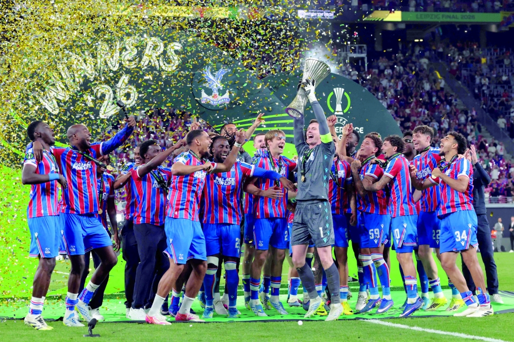 Crystal Palace's English goalkeeper #01 Dean Henderson (C-R) raises the trophy as his team celebrates after winning the UEFA Conference League final football match between Crystal Palace FC and Rayo Vallecano de Madrid in Leipzig, eastern Germany, on May 27, 2026.    (Photo by Ronny HARTMANN / AFP)
