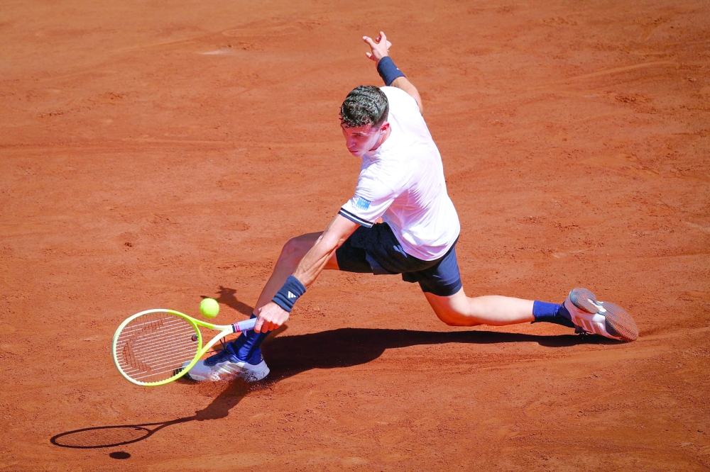 TOPSHOT - Argentina's Juan Manuel Cerundolo plays a backhand return to Italy's Jannik Sinner during their men's singles match on day 5 of the French Open tennis tournament on Court Philippe-Chatrier at the Roland-Garros Complex in Paris on May 28, 2026. (Photo by ALAIN JOCARD / AFP)
