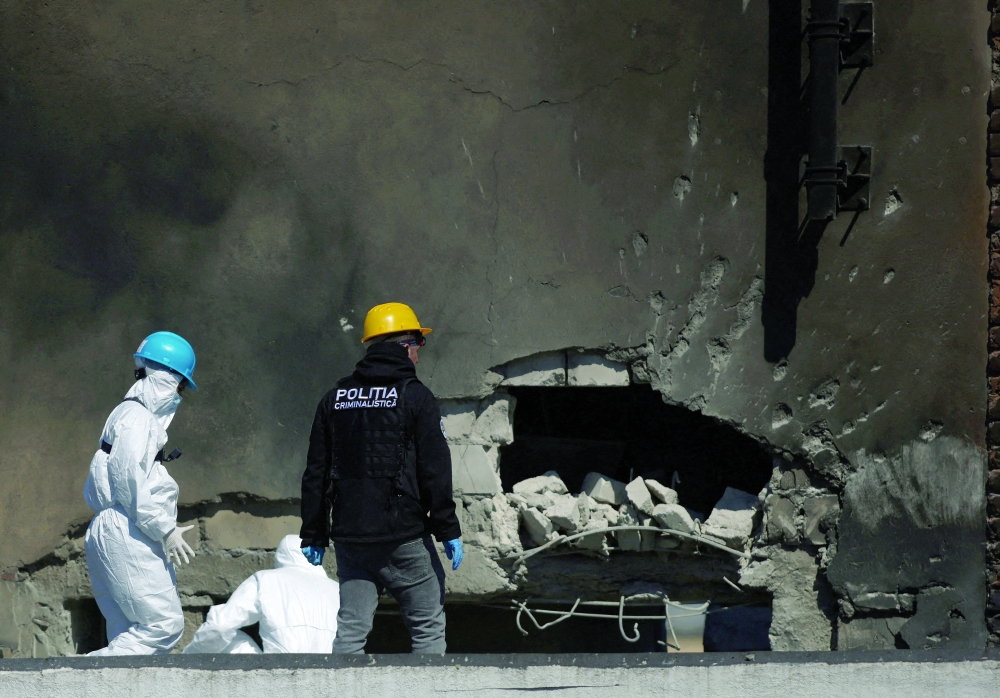 Romanian law enforcement officers work on the site of an explosion at a residential block, in Galati. — Reuters 