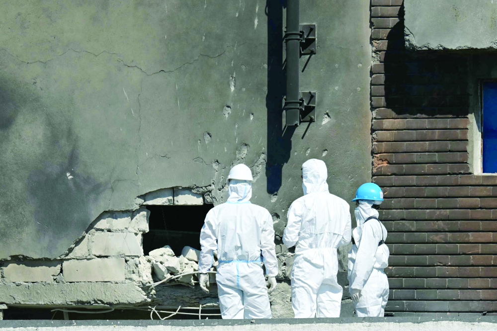 Forensic investigators examine the location of impact after a drone struck an apartment building in Galati. — AFP 