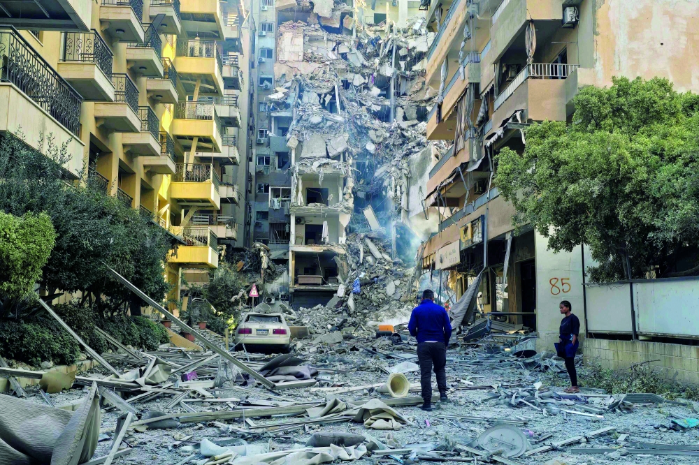 People look at the damages at the site of an Israeli strike in Tyre, southern Lebanon. — AFP