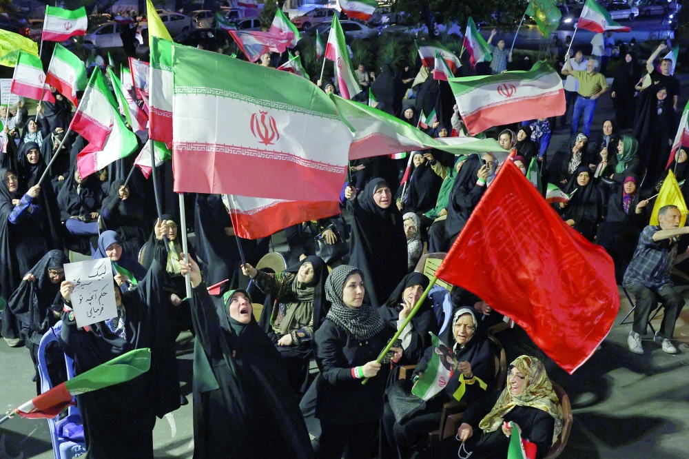 People wave Iran's national flags during an anti-US and Israel protest in Tehran. — AFP