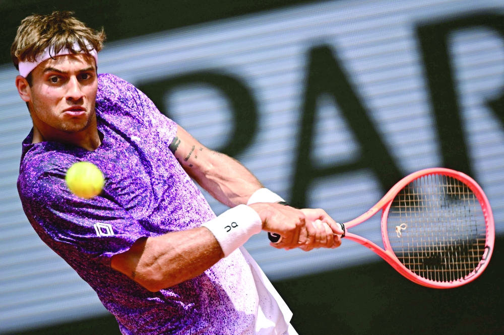 Italy's Flavio Cobolli plays a backhand return to US Learner Tien during their men's singles match on day 7 of the French Open tennis tournament on Court Philippe-Chatrier at the Roland-Garros Complex in Paris on May 30, 2026. (Photo by JULIEN DE ROSA / AFP)
