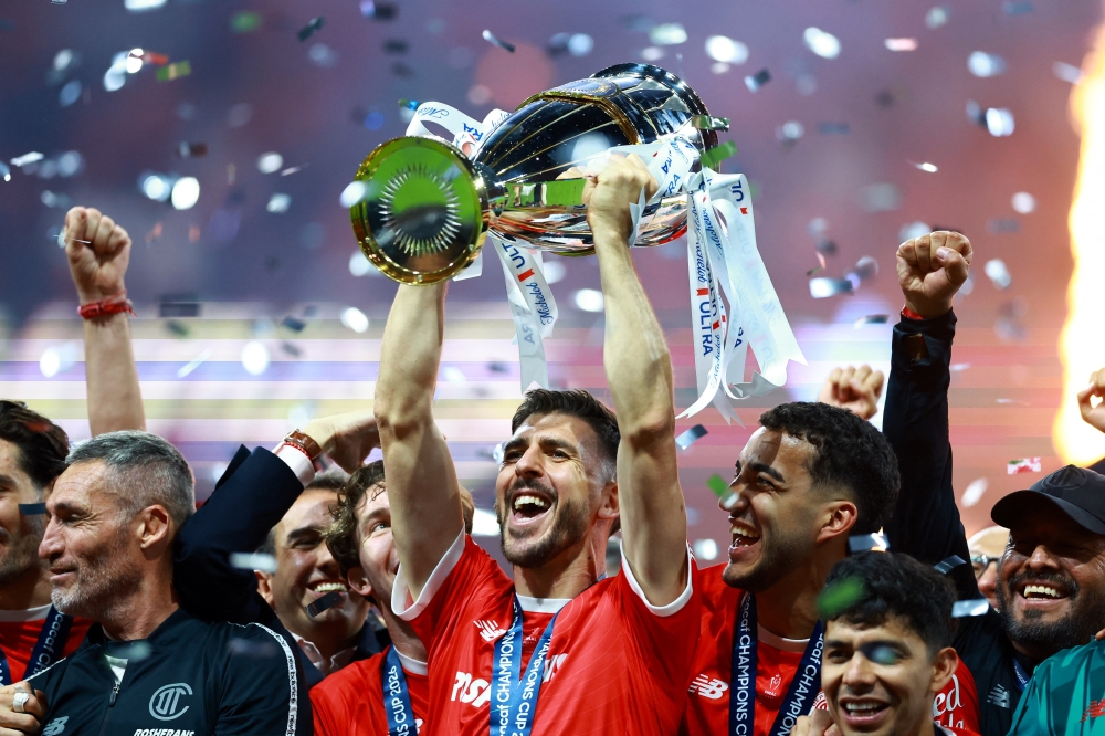  
Toluca players and staff members celebrate with the trophy after winning the CONCACAF Champions Cup  