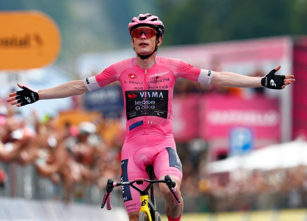   Jonas Vingegaard wearing the overall leader's pink jersey celebrates as he crossing the finish line 