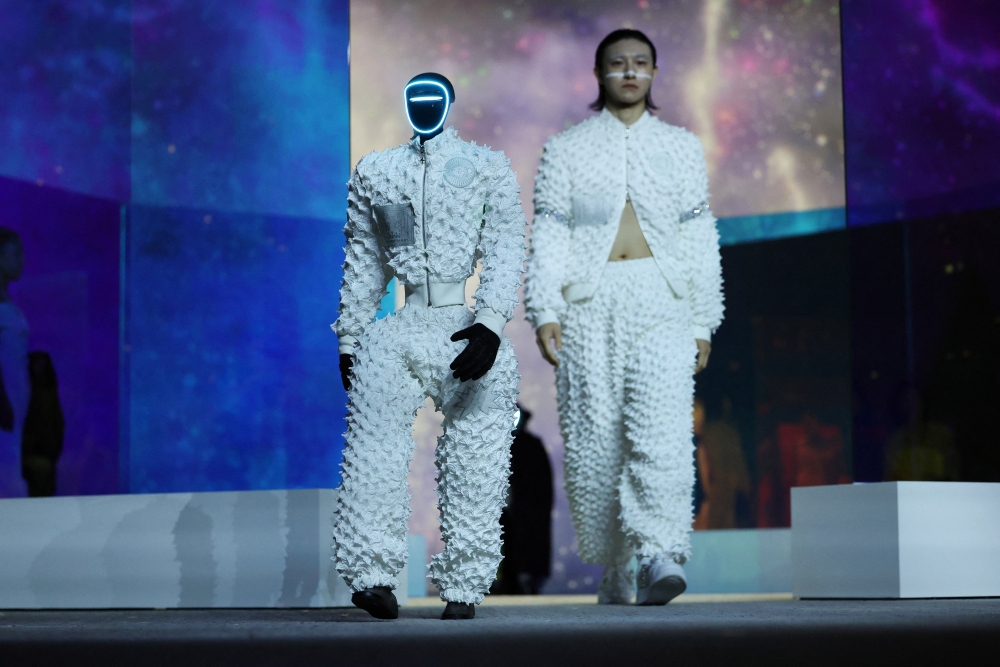A humanoid robot and a model present creations during Galaxy Corporation's Mach33: Physical AI Fashion Show in Seoul, South Korea, May 28, 2026.   REUTERS/Kim Hong-Ji