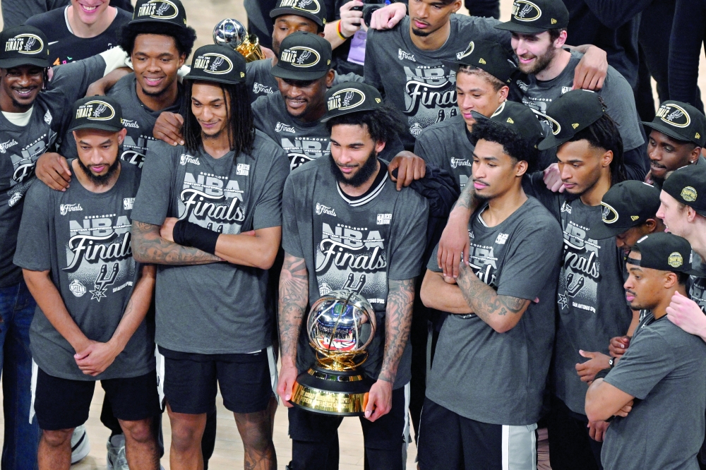 San Antonio Spurs forward Julian Champagnie (30) and team-mates celebrate with the Oscar Robertson trophy after defeating the Oklahoma City Thunder in game seven of the western conference finals. — Imagn Images
