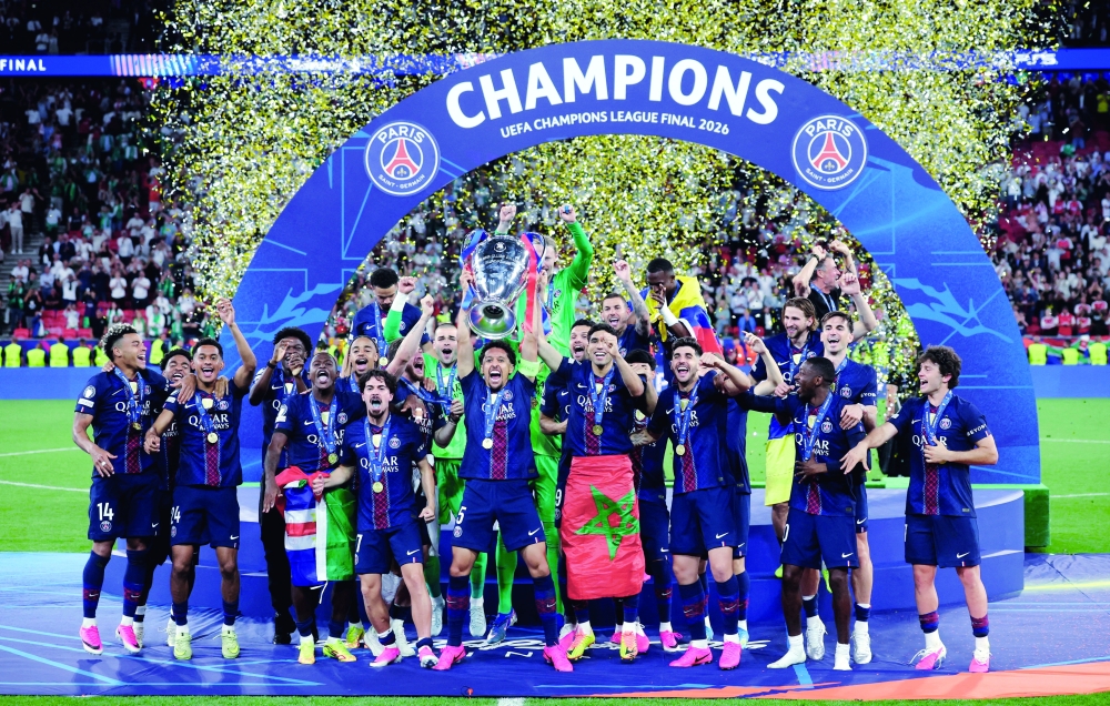 Paris St Germain's Marquinhos lifts the trophy as he celebrates with teammates after winning the UEFA Champions League. — Reuters