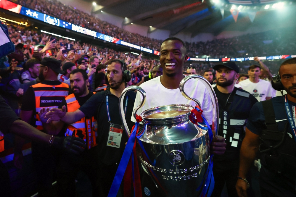 Paris Saint-Germain's Ecuadorian defender #51 Willian Pacho holds the trophy at Parc des Princes stadium 