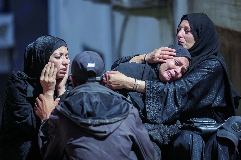 Women mourn during a funeral for ten Palestinians killed in an Israeli strike, in Gaza City. — AFP