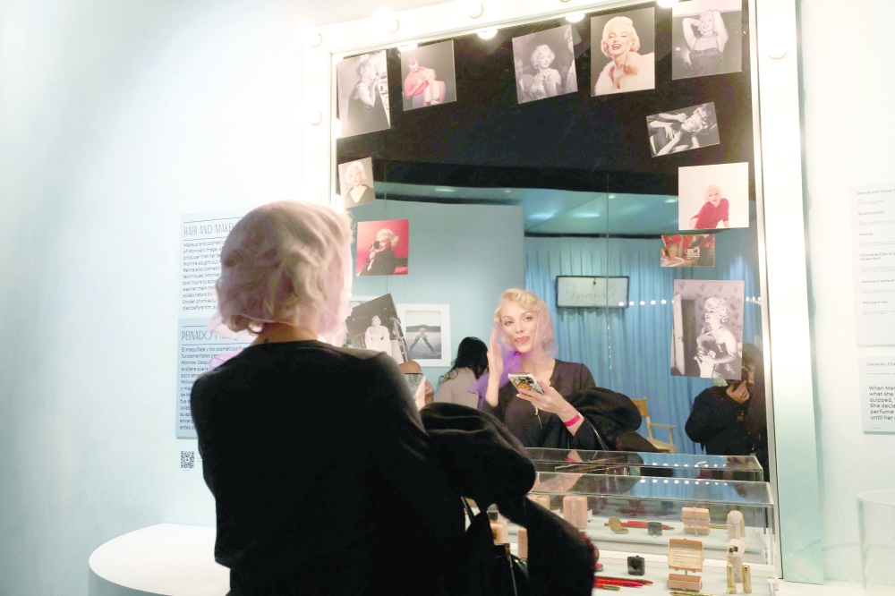 Guests do their make-up in Marilyn Monroe’s mirror during the Exhibition Preview for "Marilyn Monroe: Hollywood Icon" hosted by The Academy Museum at Academy Museum of Motion Pictures, in Los Angeles, on May 27, 2026.  (Photo by VALERIE MACON / AFP)
