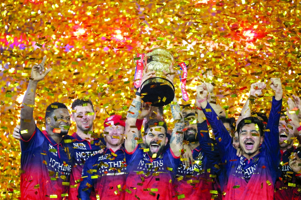 Royal Challengers Bengaluru's Virat Kohli lifts the trophy as he celebrates with teammates after winning the Indian Premier League. — Reuters