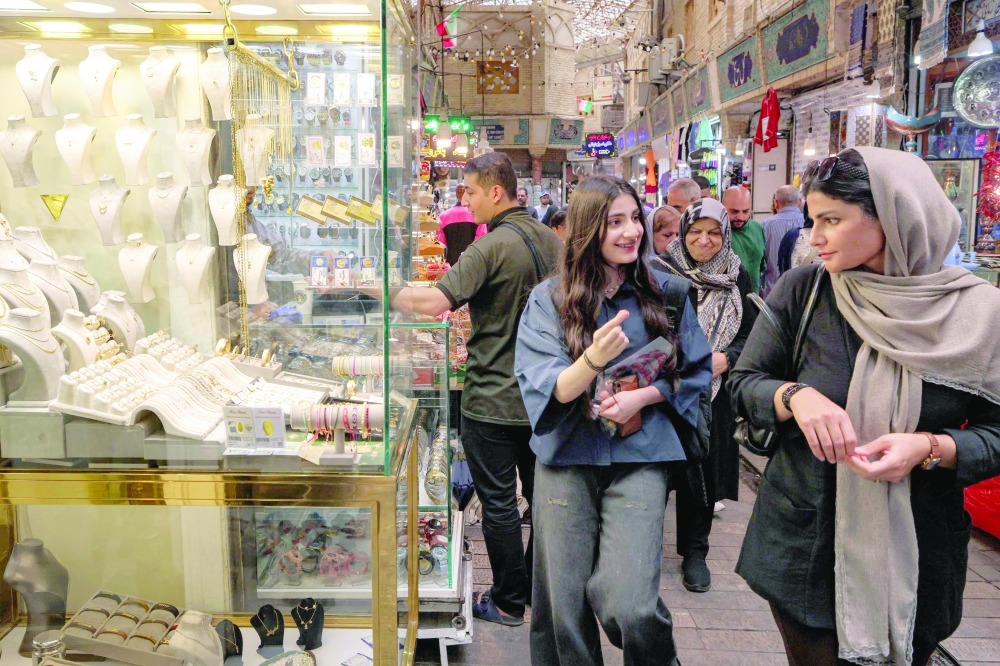 Women walk outside a jeweller's shop at the Tajrish Bazaar in Tehran on Jon Tuesday. US President Donald Trump said that talks with Iran were moving at a 'rapid pace', even as Tehran threatened to widen the war. - AFP