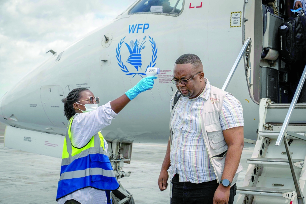 An official checks passengers' temperatures at Bunia Airport in eastern Democratic Republic of the Congo on Wednesday. - AFP