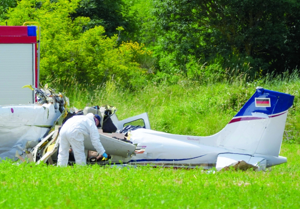 A police officer in protective gear collects evidence at the site of a small plane crash, which killed 4 people, in Medulin on Croatia's northern Adriatic coast. - AFP 