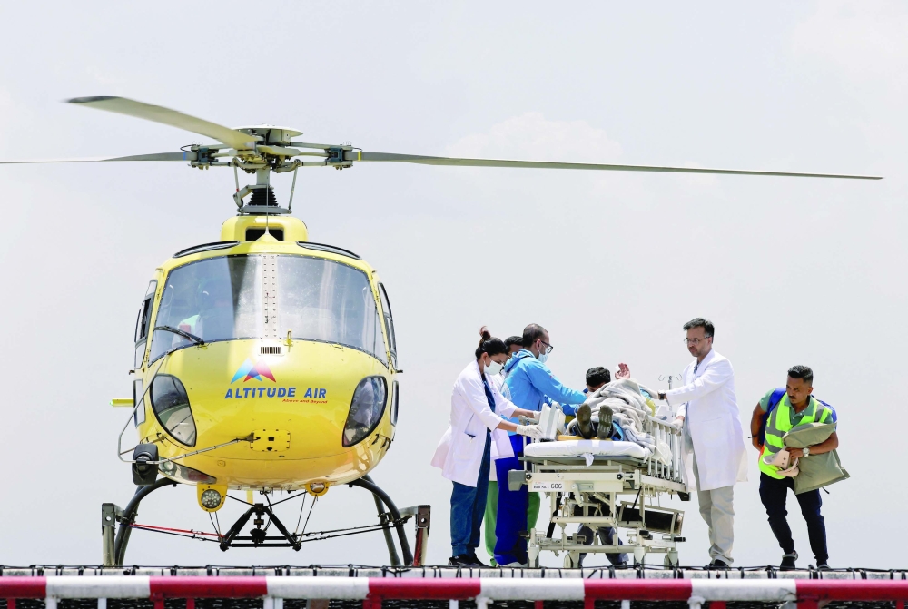 Paramedics work to transport Dawa Sherpa, who was missing for several days in the Everest region, from the helipad at HAMS Hospital in Kathmandu, Nepal. - Reuters
