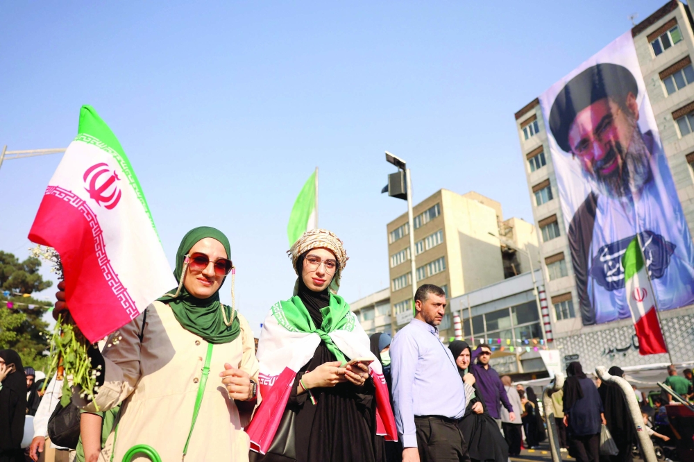 A woman waves Iran's national flag during a rally in support of the country's supreme leader Mojtaba Khamenei and commemorate Eid al-Ghadir in Tehran on Thursday. - AFP