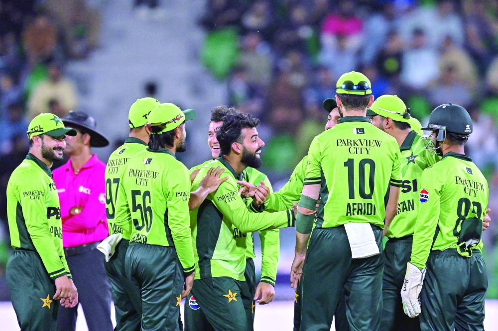 Pakistan's Shadab Khan (C) celebrates with teammates after taking the wicket of Australia's Oliver Peake during the third one-day international (ODI) cricket match between Australia and Pakistan at Gaddafi Stadium 