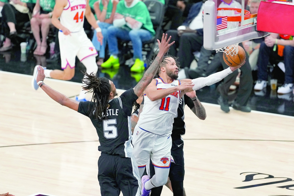 New York Knicks' Jalen Brunson (11) drives to the basket past San Antonio Spurs' Stephon Castle (5) during game one of the 2026 NBA Finals 
