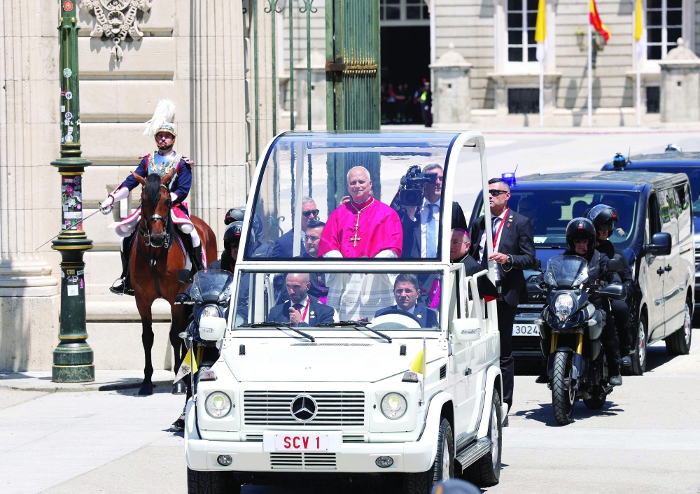 Pope Leo XIV leaves in his popemobile after a welcome ceremony at the Royal Palace in Madrid. — AFP