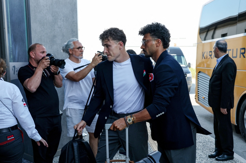 Ramin Iran's defender #23 Ramin Rezaeian (R) descends form a bus as the Iranian national football team arrives at Antalya Airport for their departure to Mexico ahead of the FIFA 2026 