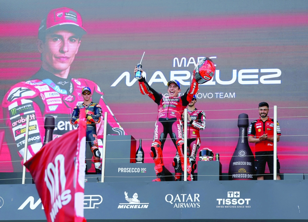 Ducati Lenovo Team's Marc Marquez celebrates on the podium with a trophy after winning his 100th MotoGP race