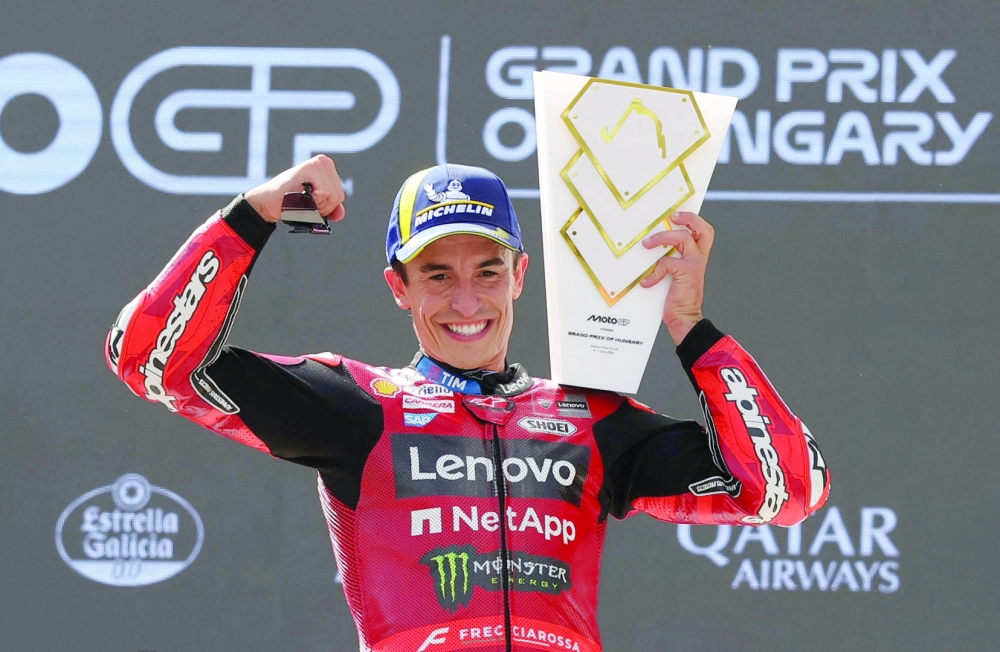 Ducati Lenovo Team's Marc Marquez celebrates on the podium with a trophy after winning his 100th MotoGP race