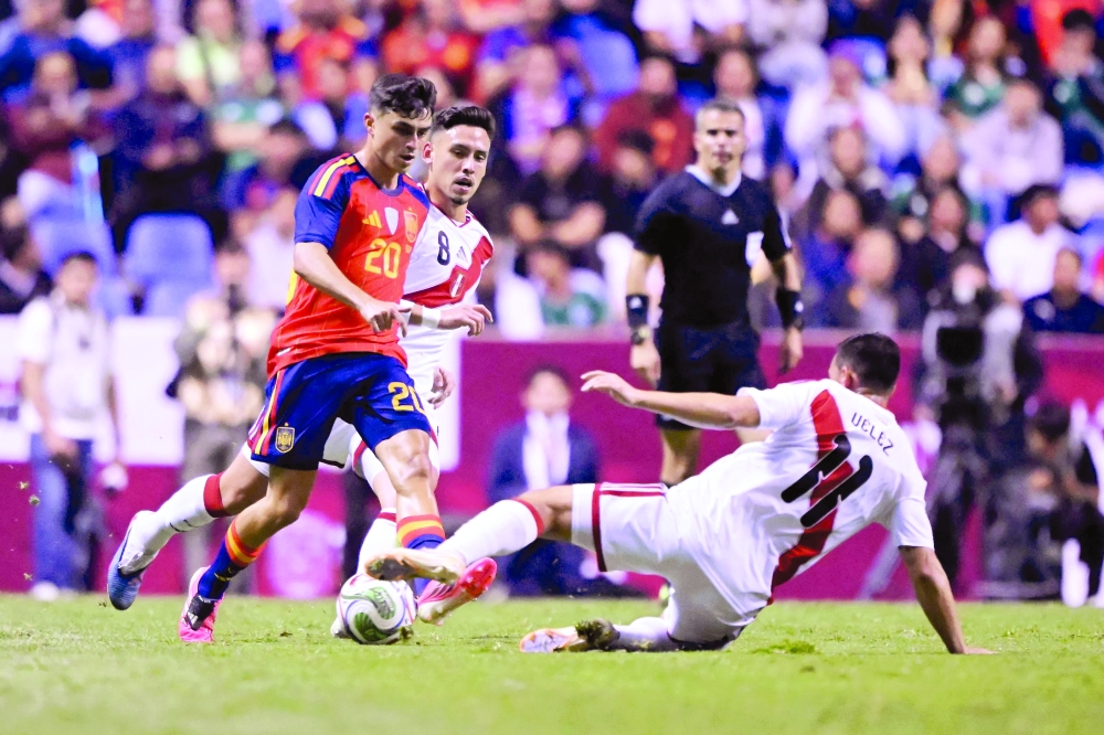 Spain's midfielder #20 Pedri conrols the ball while Peru's midfielder #11 Jairo Velez defends during their international friendly at Cuauhtemoc Stadium in Puebla, Mexico. — AFP