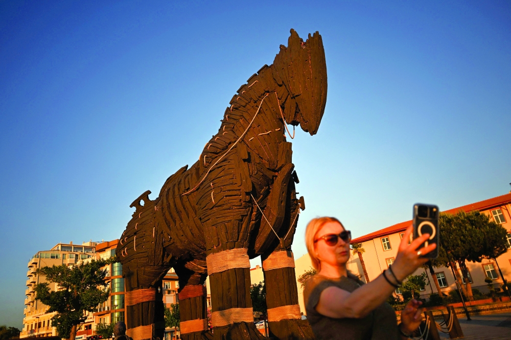 A tourist takes a selfie photograph in front of the Trojan Horse, which was donated to be displayed at Çanakkale Square following the release of the movie 'Troy' in Çanakkale. — AFP
