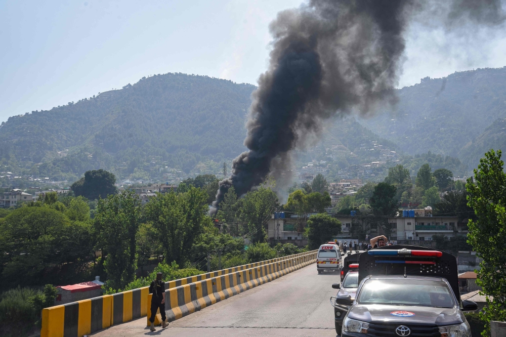 Smoke billows from the site following a crash of a Pakistan military helicopter in Muzaffarabad, the capital of Pakistan-administered Kashmir on June 10
