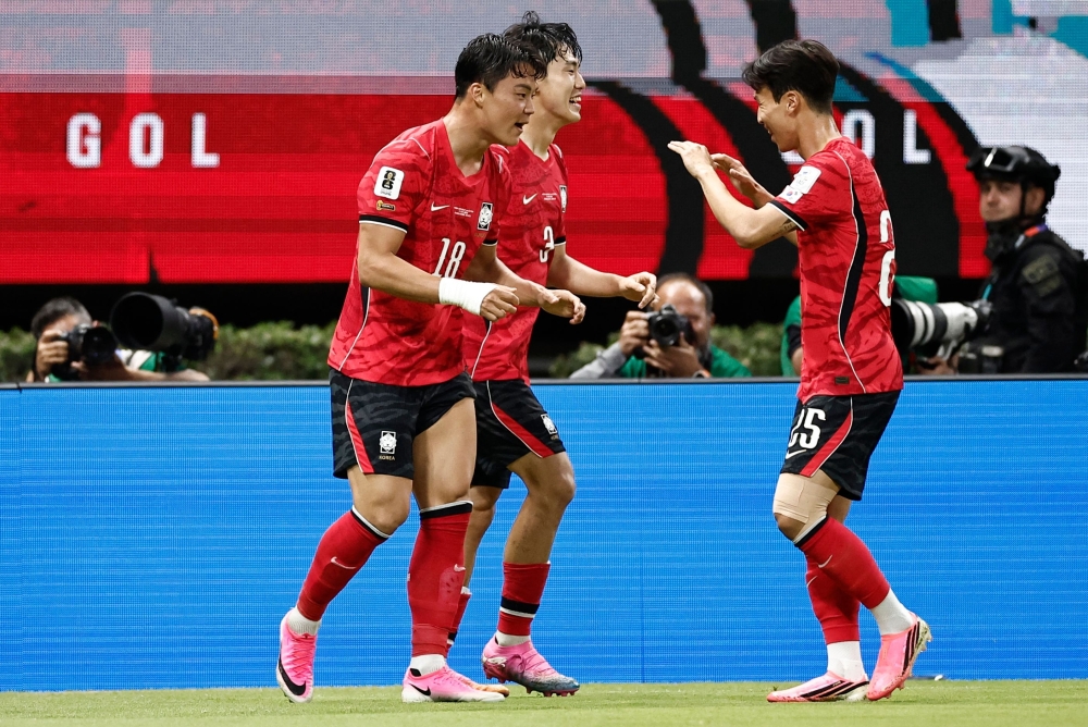 South Korea's forward #18 Oh Hyeon-gyu celebrates with teammate midfielder #25 Eom Ji-sung scoring his team's second goal. — AFP