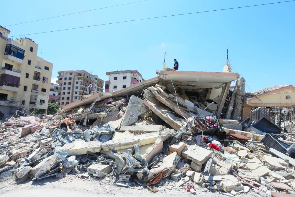 People inspect the site an Israeli strike in Tyre, Lebanon