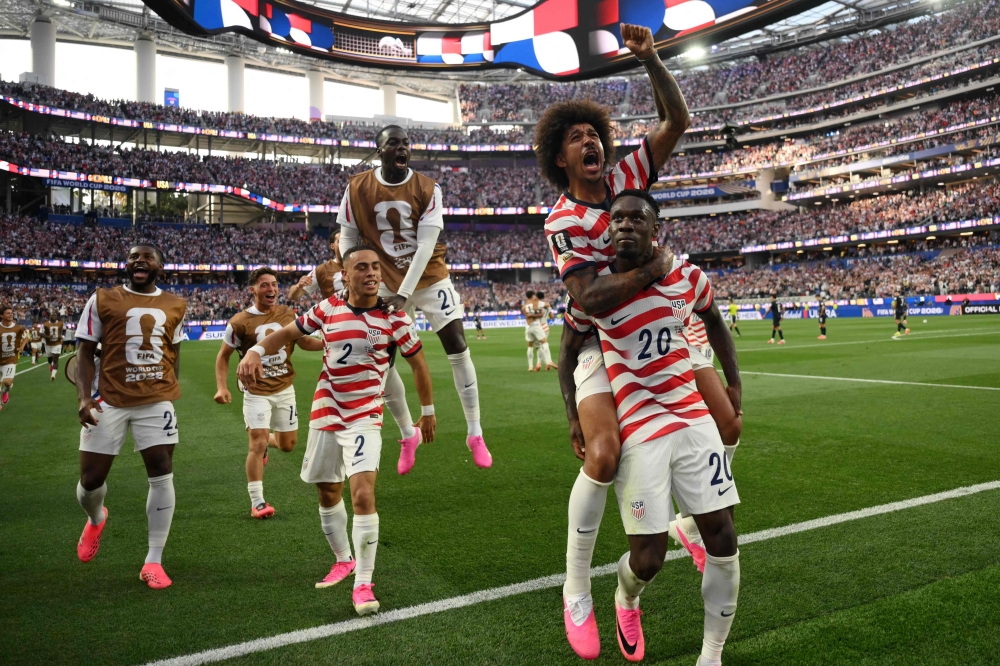 US forward #20 Folarin Balogun celebrates with teammates after scoring his team's third goal. — AFP
