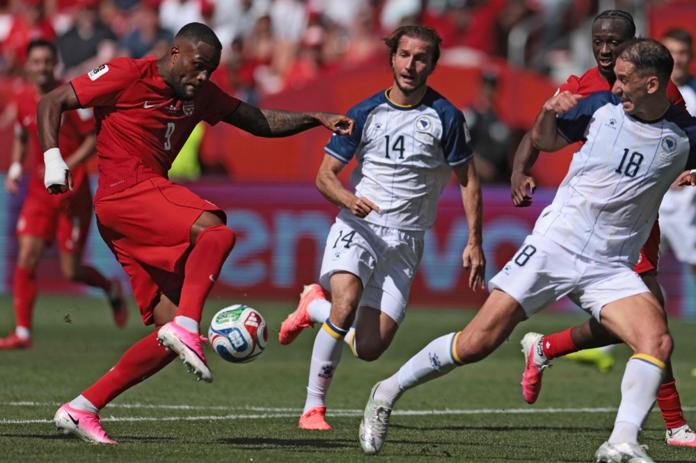 Canada's forward #09 Cyle Larin (L) scores the equalizer  . — AFP