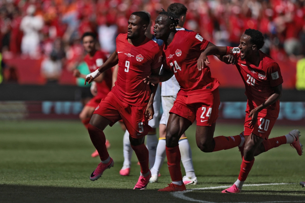 Canada's forward #09 Cyle Larin (L) celebrates after scoring a goal. — AFP