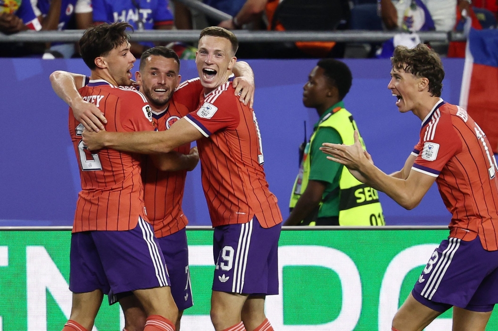 Scotland's midfielder #07 John McGinn (2nd L) celebrates with teammates after scoring his team's first goal. — AFP
