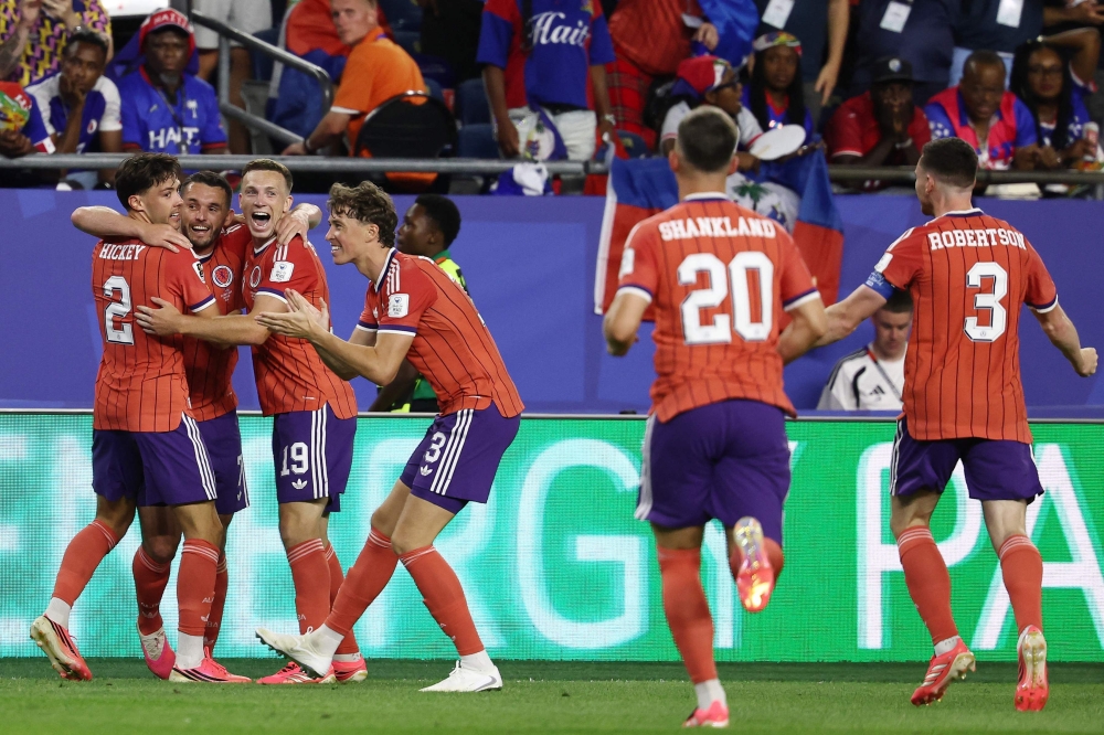 Scotland's midfielder #07 John McGinn (2nd L) celebrates with teammates after scoring his team's first goal. — AFP  