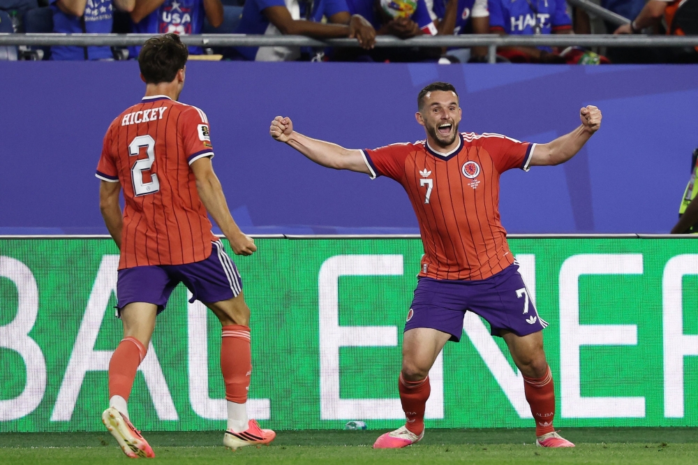 Scotland's midfielder #07 John McGinn celebrates with teammate defender #02 Aaron Hickey after scoring his team's first goal. — AFP
