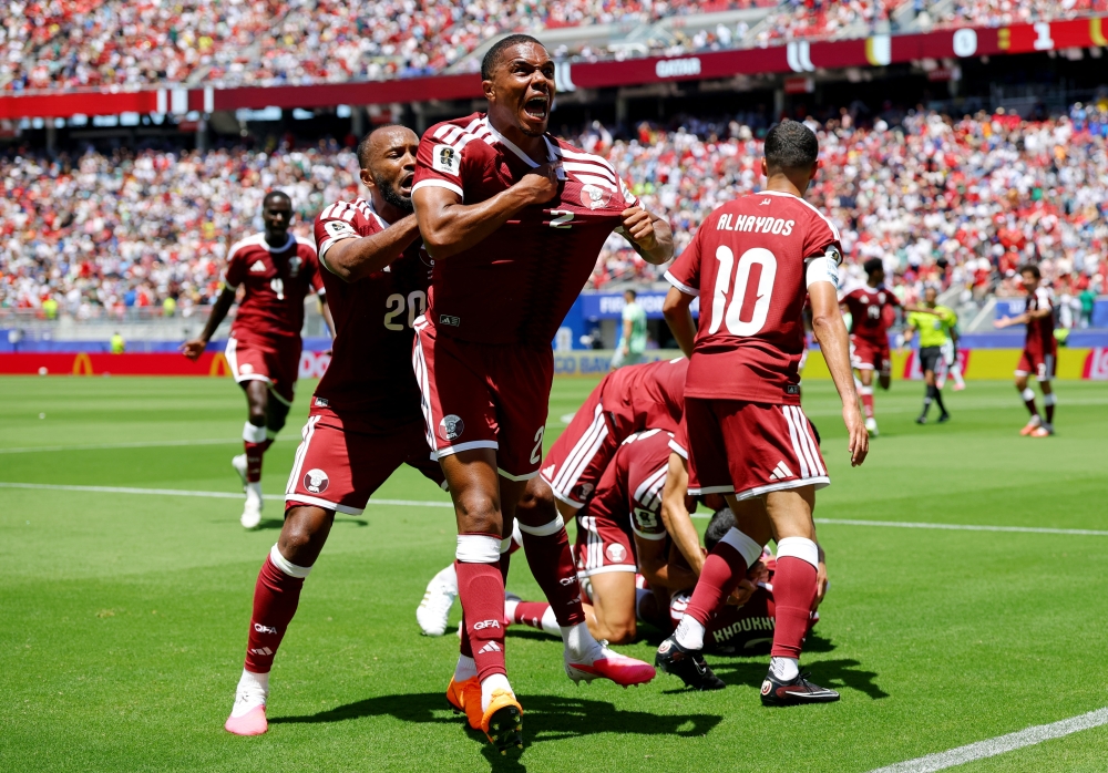  
Qatar's Pedro Miguel and Ahmed Fathy celebrate after Boualem Khoukhi scored their first goal. — Reuters