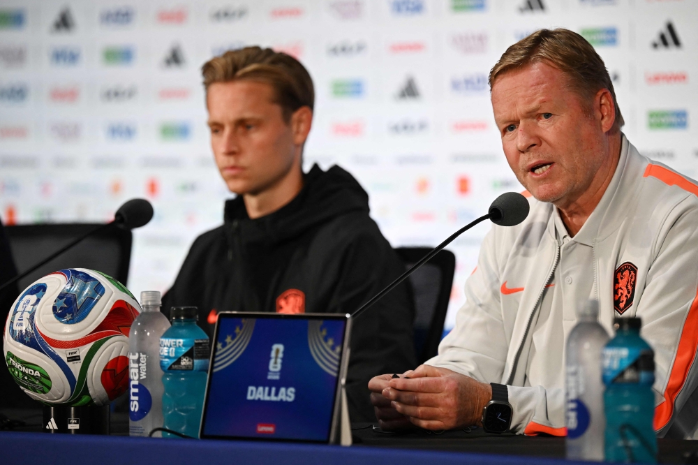 Netherlands' midfielder #21 Frenkie de Jong and Netherlands' head coach Ronald Koeman attend a press conference. — AFP