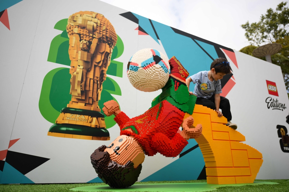 A child climbs on a LEGO figure of Portugal's forward #7 Cristiano Ronaldo. — AFP
