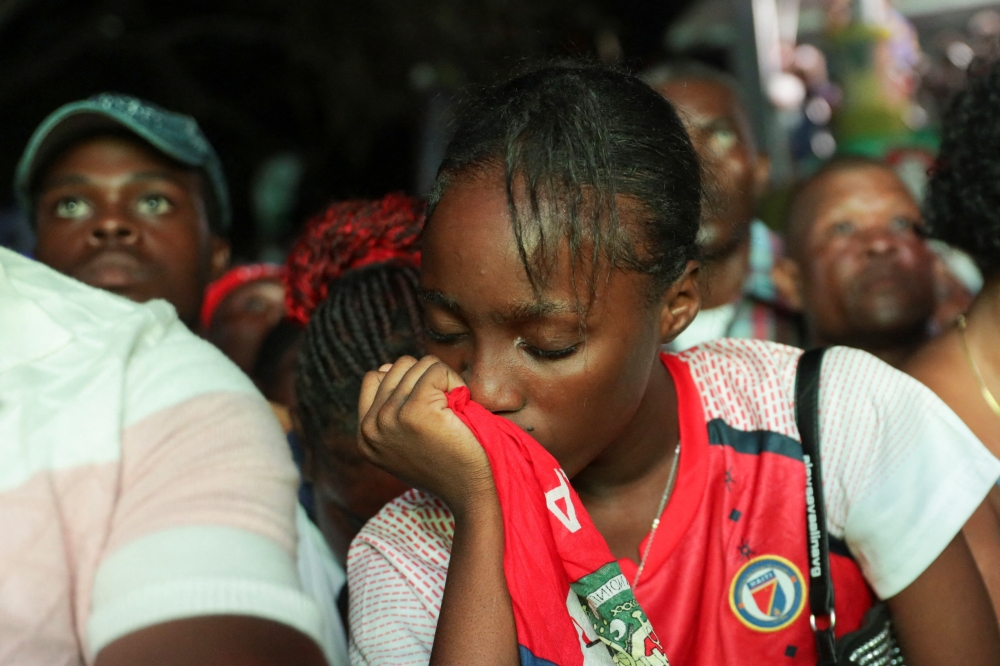 A Haitian fan reacts while watching the match between Haiti and Scotland. — AFP