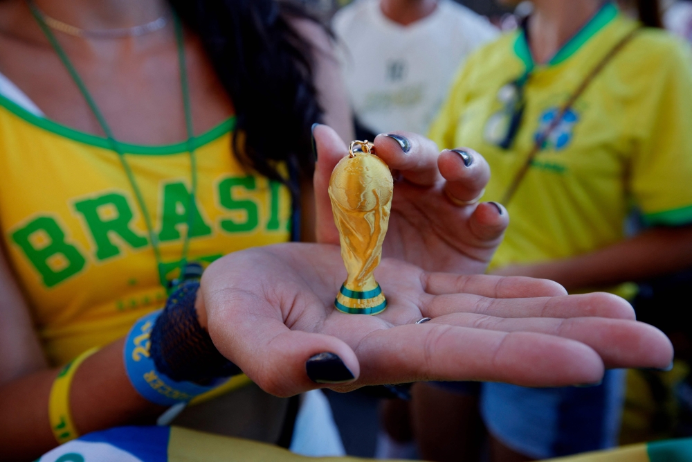 A Brazil fan displays a World Cup trophy keychain. — AFP