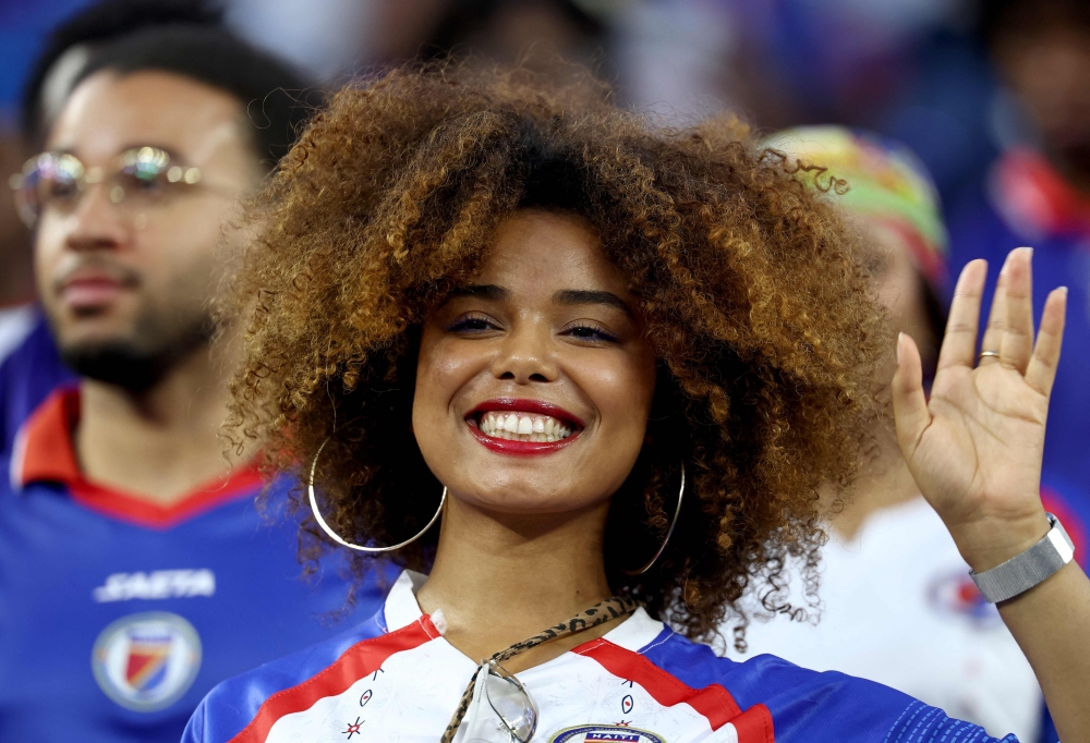 A Haiti fan poses for pictures ahead of the match. — AFP
