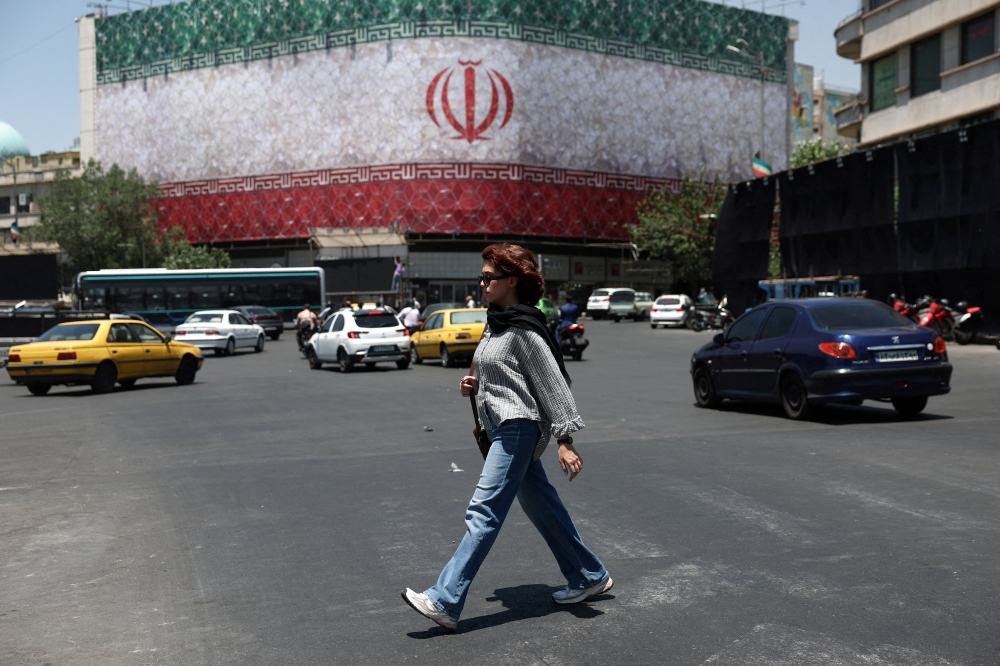 A woman walks on a street in Tehran, Iran, June 14, 2026.