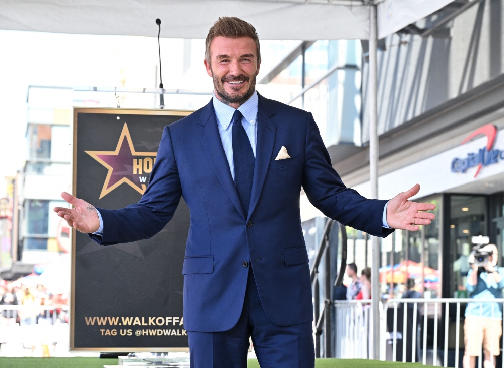 English former footballer David Beckham poses at his newly unveiled Hollywood Walk of Fame star during a ceremony in Hollywood, California. -AFP 