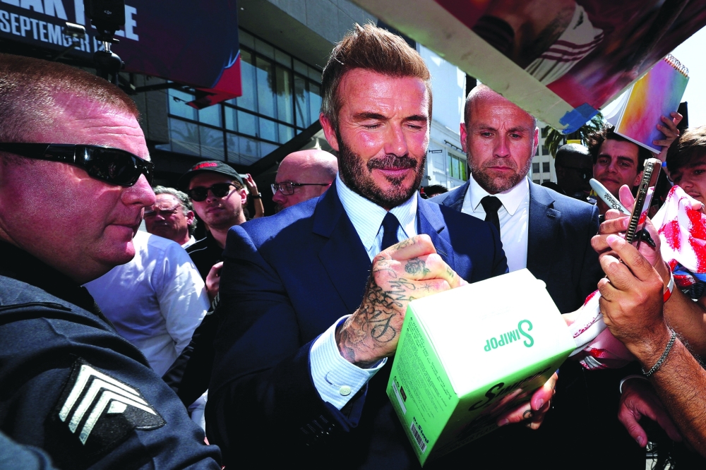 David Beckham signs autographs during his star unveiling ceremony on the Hollywood Walk of Fame, in Los Angeles, California. -Reuters 