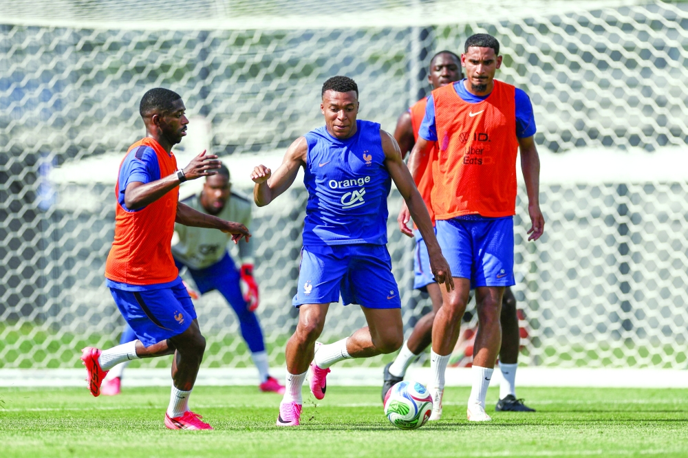 France's forward #10 Kylian Mbappe (C) and France's forward #07 Ousmane Dembele (L) take part in a training session at Bentley University. — AFP