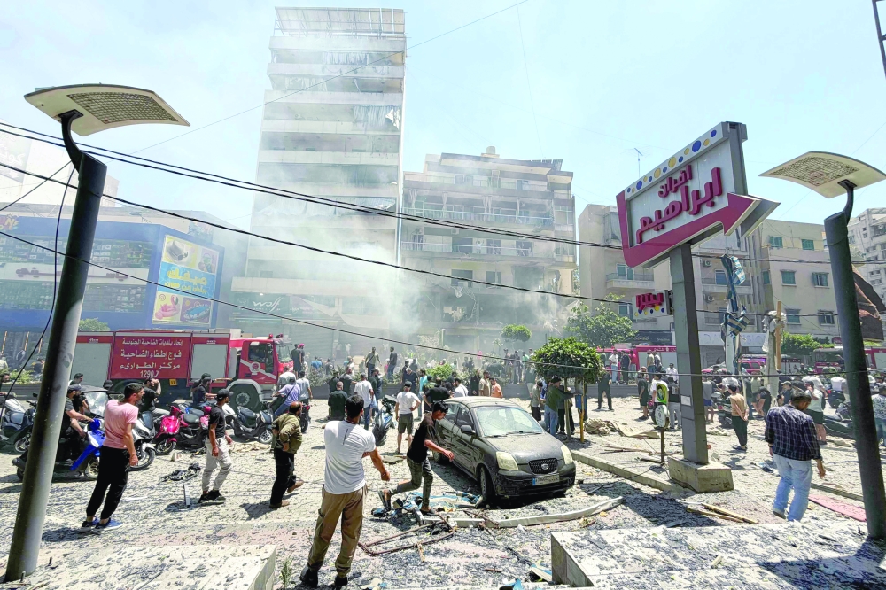 People gather at the site of an Israeli air strike that targeted a building in Beirut’s southern suburbs. — AFP