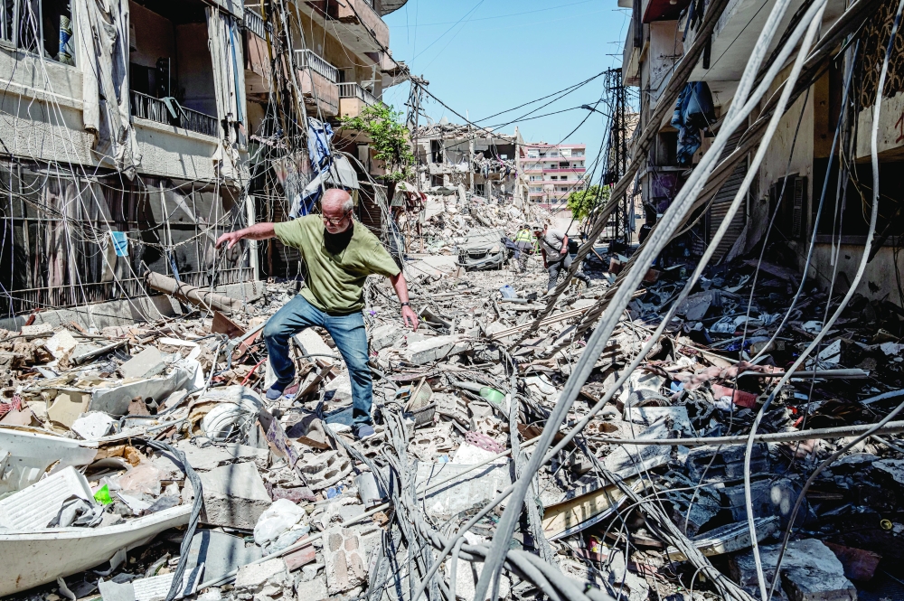 A man clambers over the rubble choking a street in the southern port city of Tyre, Lebanon. — NYT